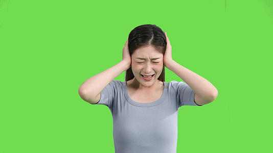 4k穿休闲装的女生捂耳朵吵闹烦恼绿幕视频视频的预览图