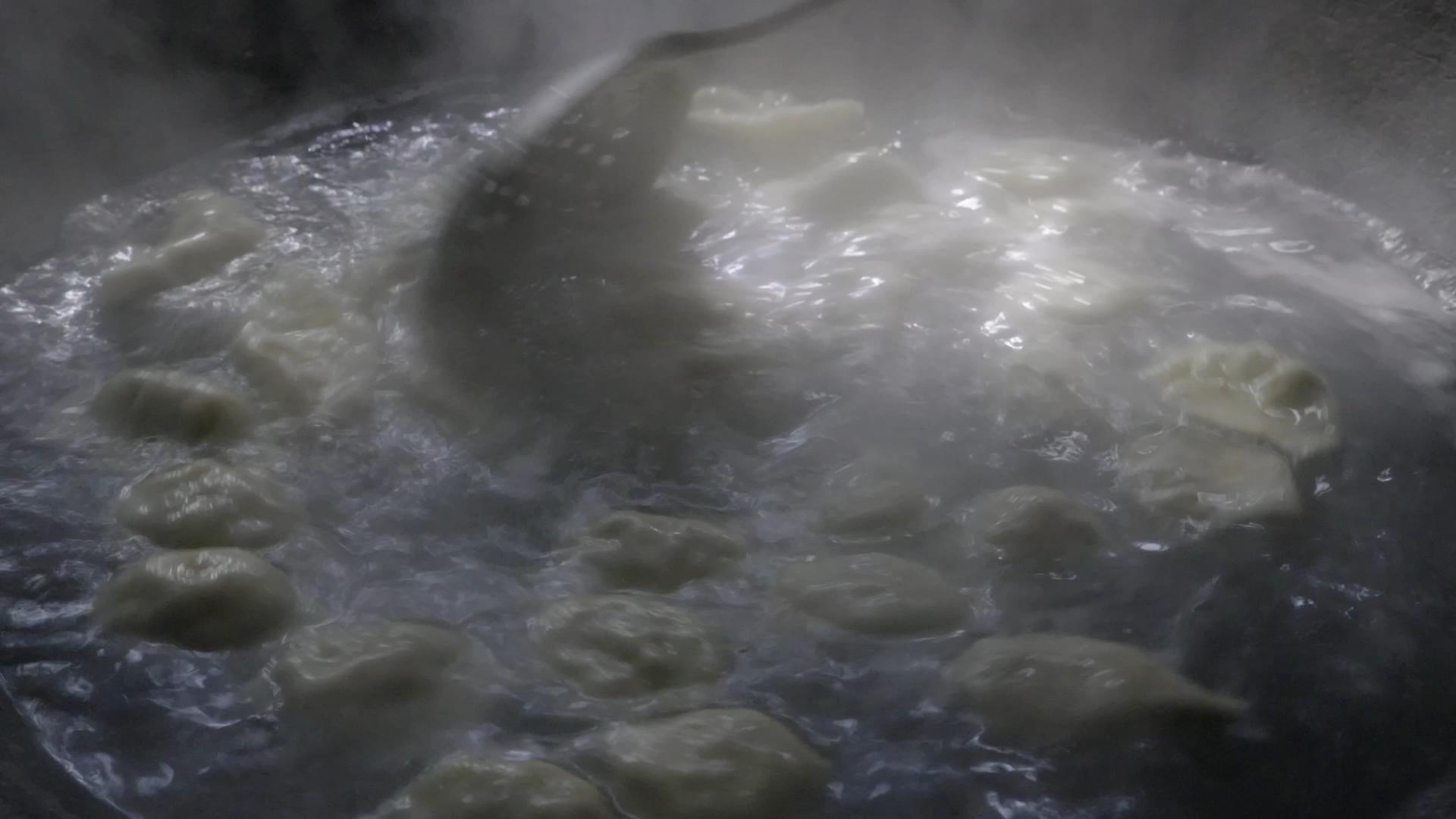4K实拍灶台锅里勺子搅动饺子视频素材视频的预览图