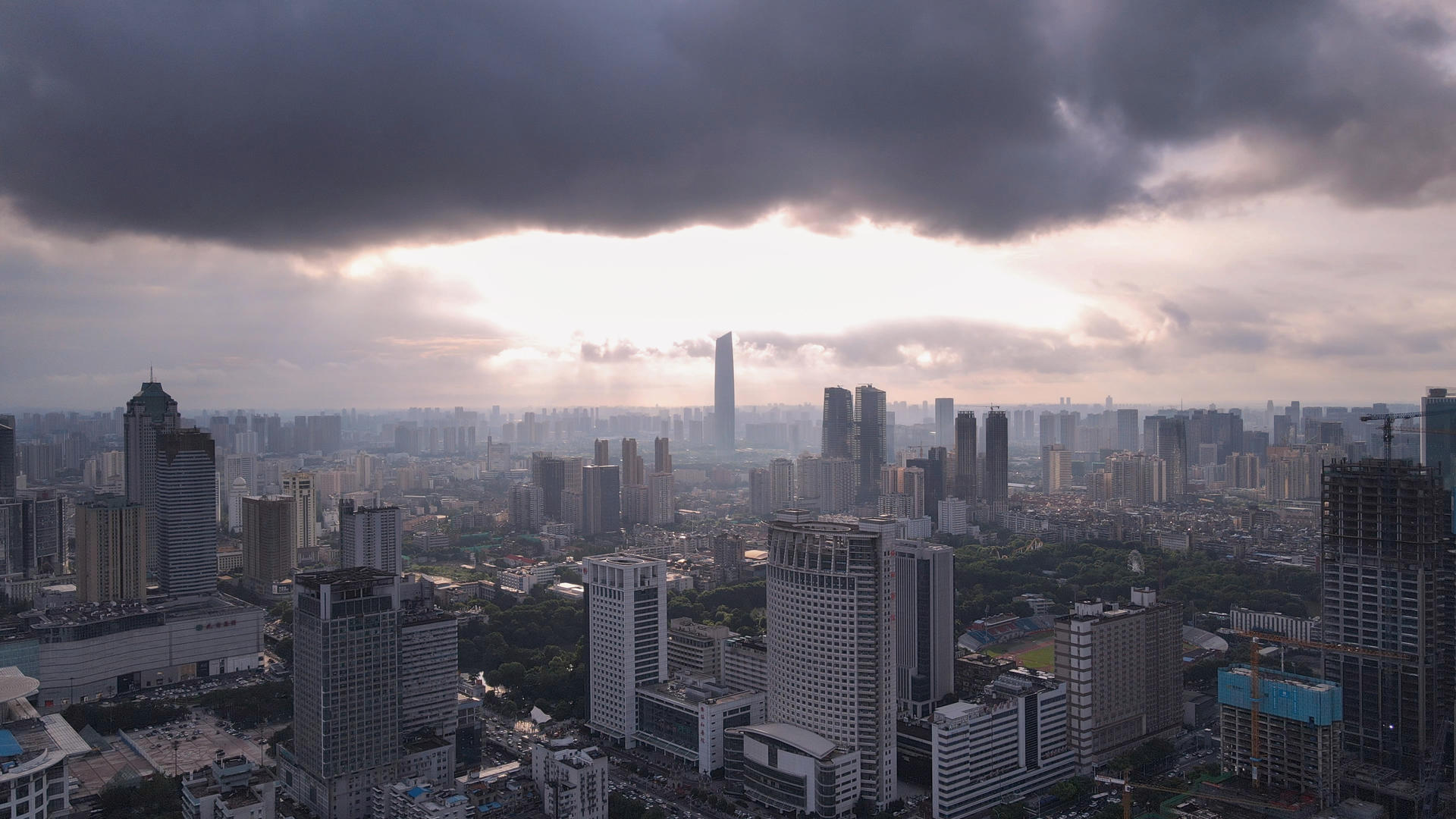 航拍风光城市乌云笼罩下的夕阳阳光晚霞天空城市天际线素材视频的预览图