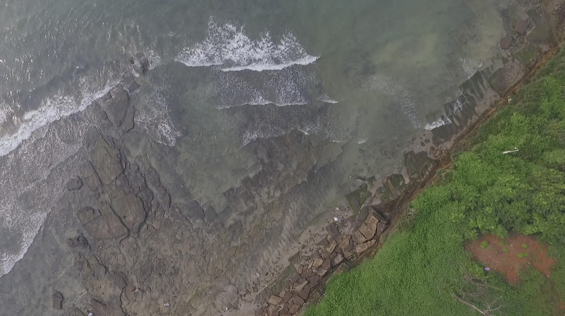 空中俯拍海浪潮汐拍打海岸礁石视频的预览图