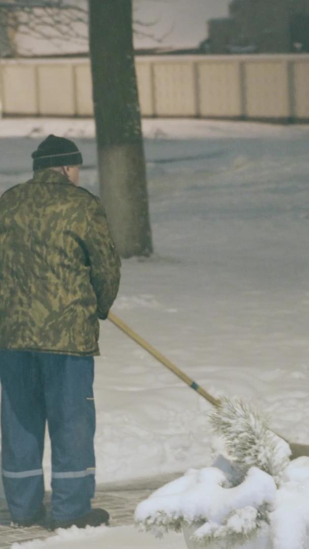 夜间人行道加班扫雪的工人视频的预览图