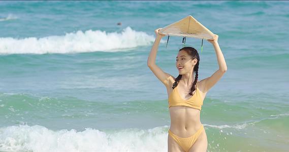 8K海边比基尼女性手举冲浪板视频的预览图