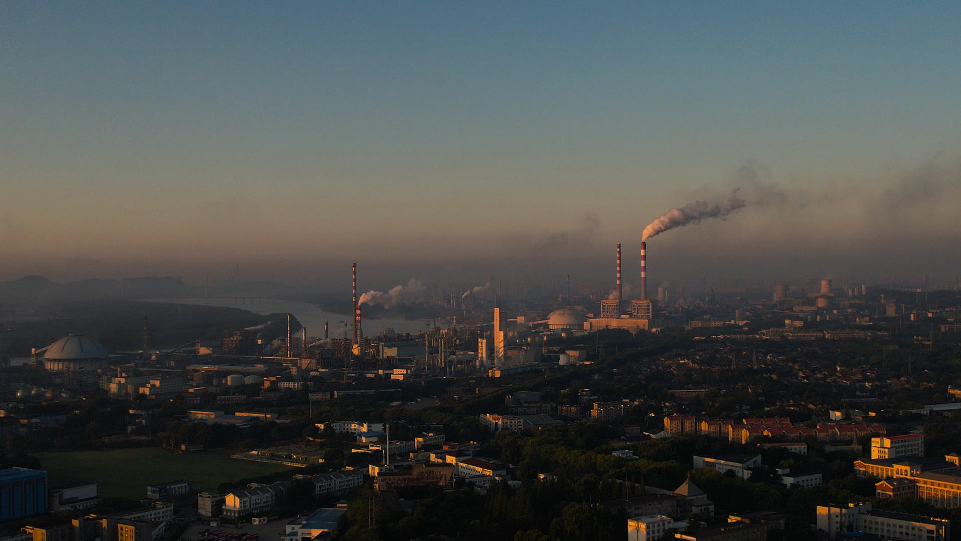 4K航拍晨曦太阳升起化工厂大烟囱废气排放视频的预览图