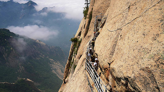 陕西旅游西岳华山最险段长空栈道悬崖旁的游客与云海4k素材视频的预览图
