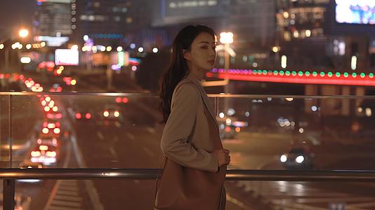 夜晚走在天桥上的年轻女性视频的预览图