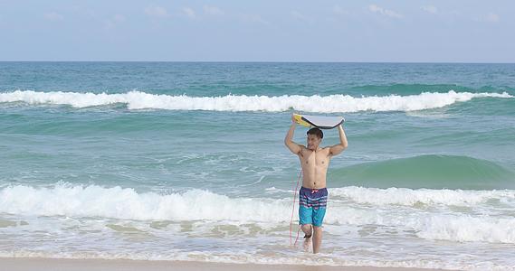 8K海边男青年手举冲浪板视频的预览图