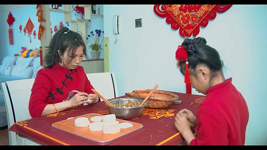 4K实拍新年妈妈和女儿在家包饺子视频的预览图