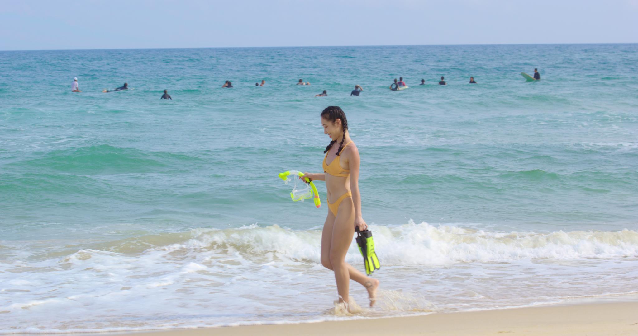 8K海边女性拿着潜水装备走在沙滩上视频的预览图
