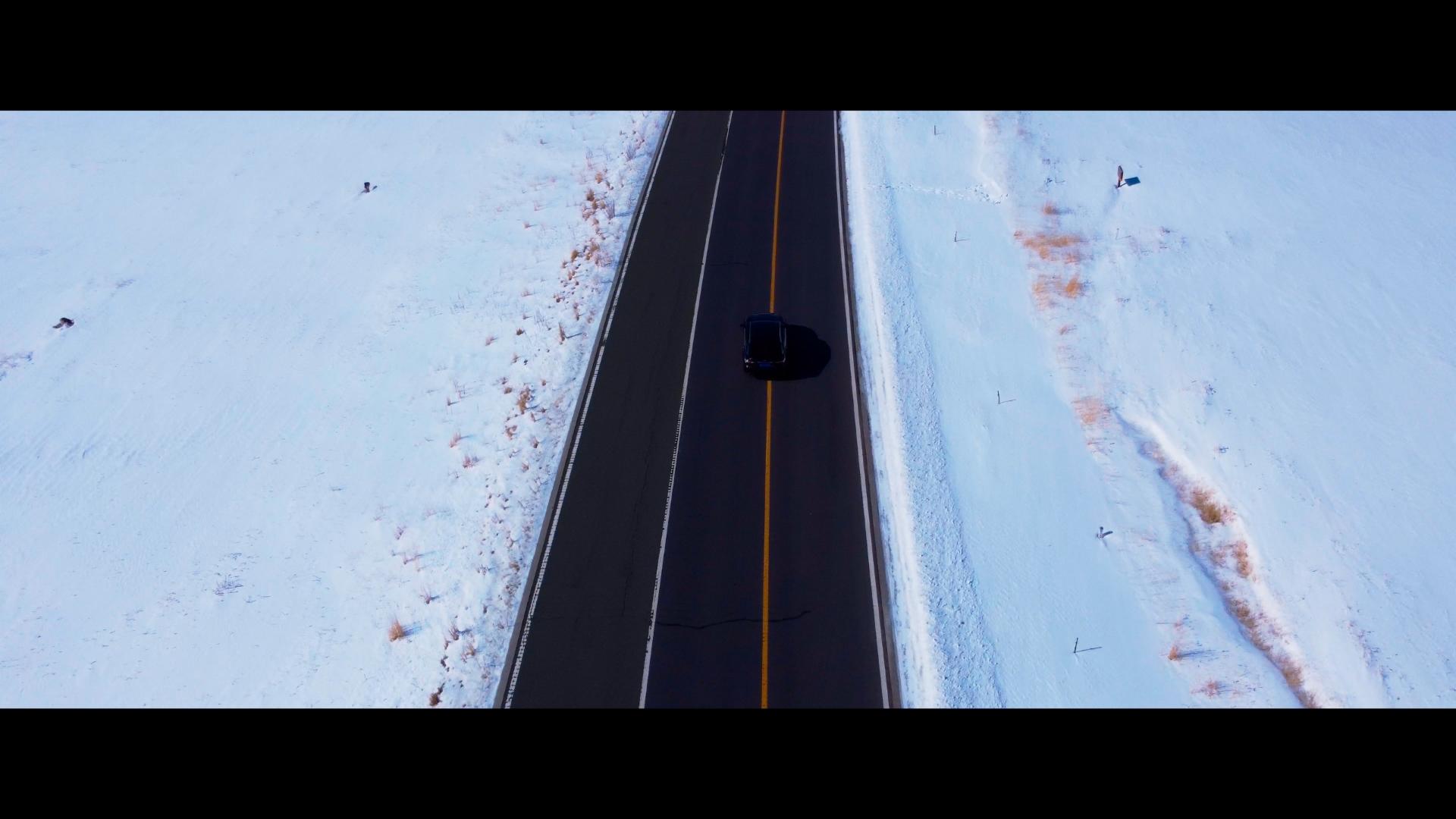 在新疆X203国道雪山学地道路车辆行驶并拍摄远景视频的预览图