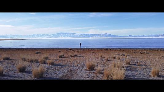 航拍赛里木湖冰面人物背影旅拍视频的预览图