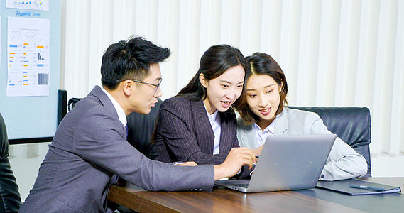 4k商务办公三个人在办公桌前使用笔记本电脑办公慢动作视频视频的预览图