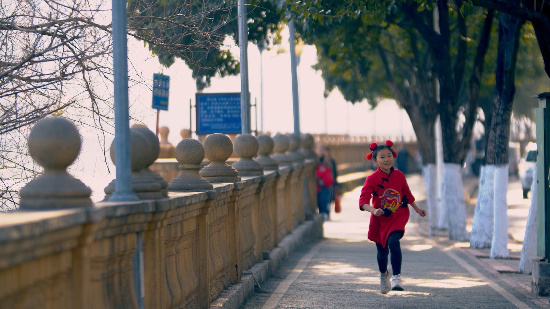 4K实拍新年喜庆小女孩在街头奔跑视频素材视频的预览图