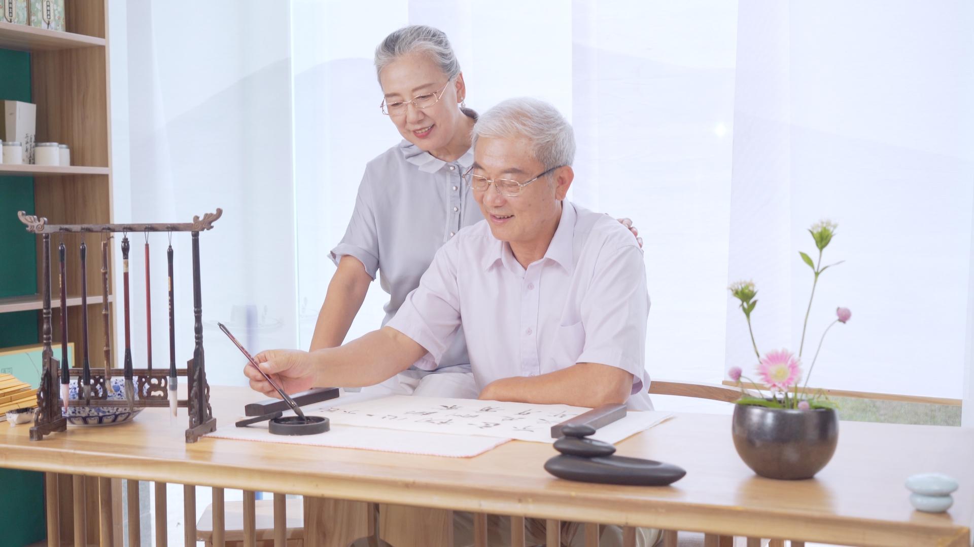 4K老年夫妇在桌子上写书法视频的预览图
