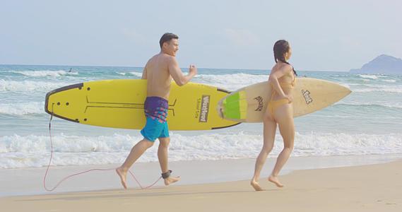 8K海边拿着冲浪板嬉戏的泳装情侣视频的预览图