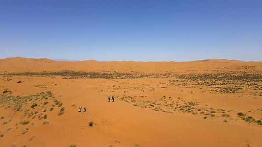 航拍在沙漠中徒步旅行的人视频的预览图