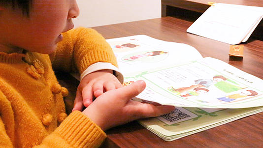 小女孩结合手机看书学习视频的预览图