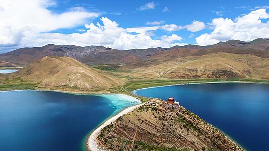 航拍西藏蓝色圣湖羊湖与湖中小岛日托寺视频视频的预览图