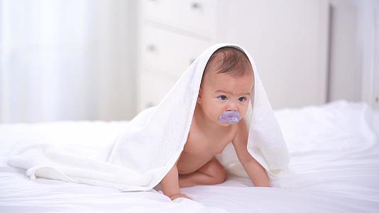 4k披着毛毯的婴儿在床上爬行视频的预览图