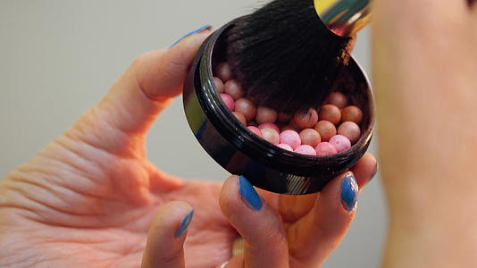 女化妆师在化妆刷上用彩蛋脸红视频的预览图