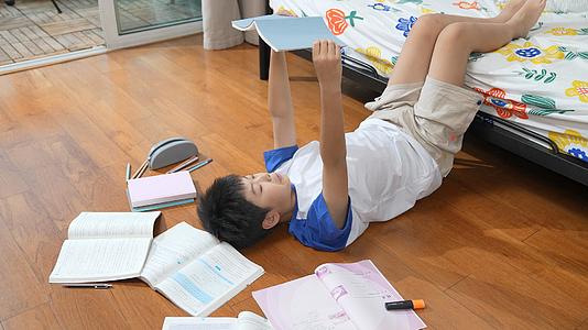 男孩躺在地板上看书视频的预览图