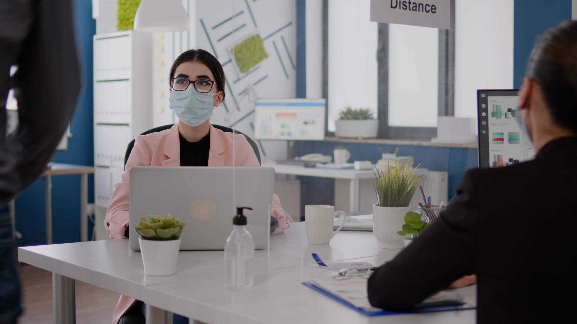 商务人士戴着医用口罩在办公室一起工作视频的预览图