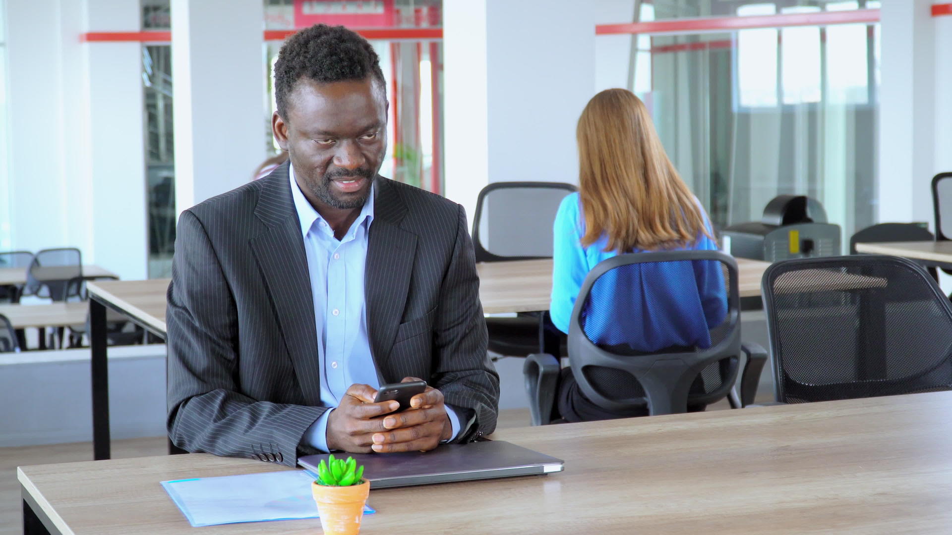 AfricanAfricanAmerican拥有智能手机的主管经理在开业公司开放空间办公室的员工中工作视频的预览图