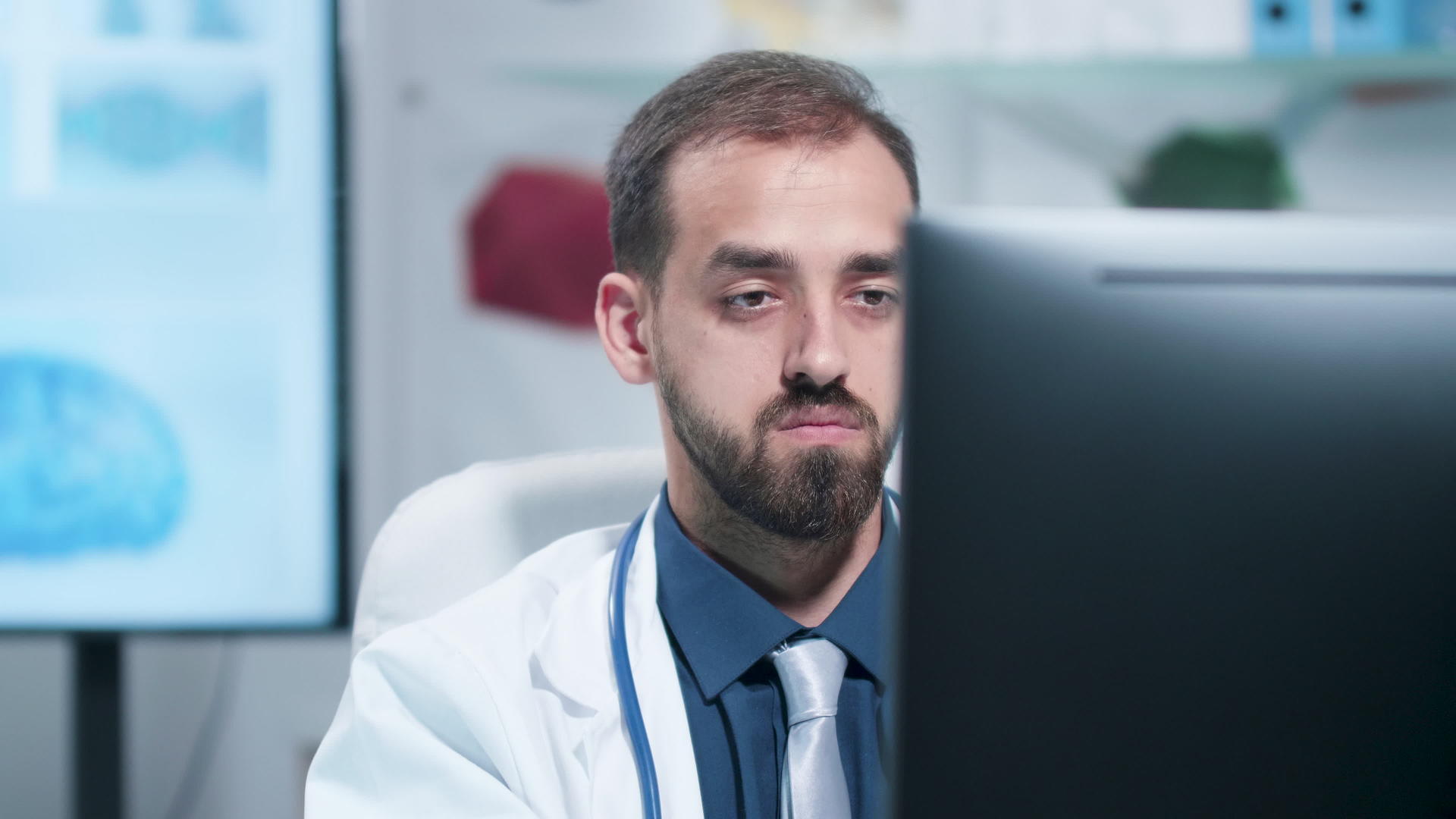 在电脑上工作的疲劳和疲惫的医生近距离拍摄社交视频的预览图