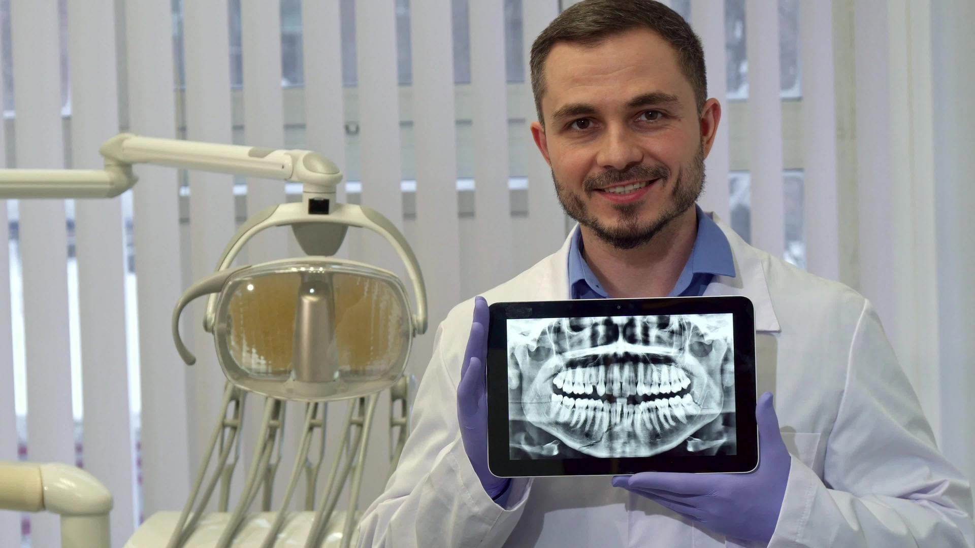 牙医在平板电脑上展示人牙X光片视频的预览图