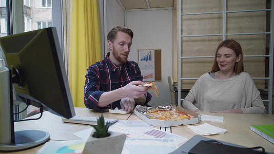男人和女人在工作场所吃披萨视频的预览图