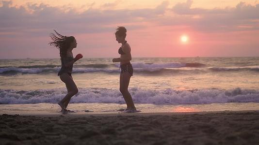 日出时大师和他的学生在海滩上打架—剪影—关于人、生活方式和运动的概念视频的预览图
