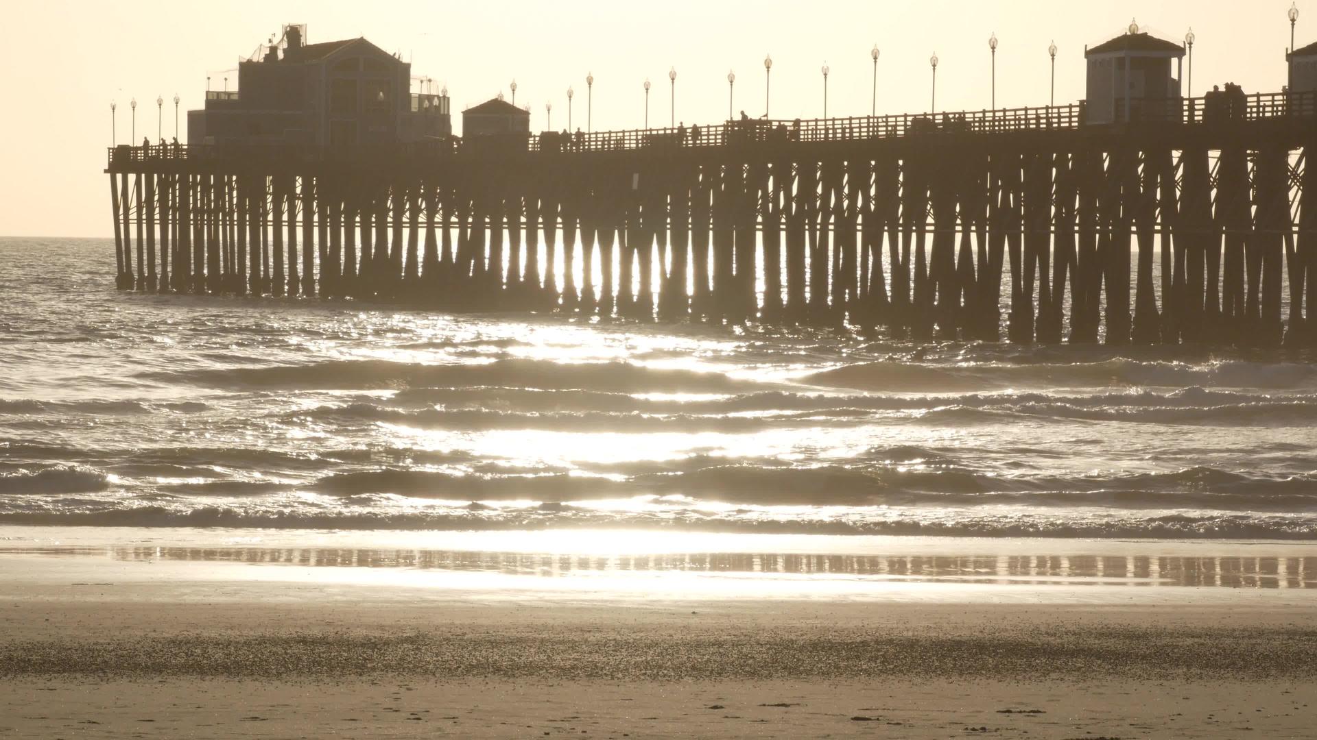桩上的木码头日落时的剪影加利福尼亚州海滨日落时阳光明媚的海浪视频的预览图