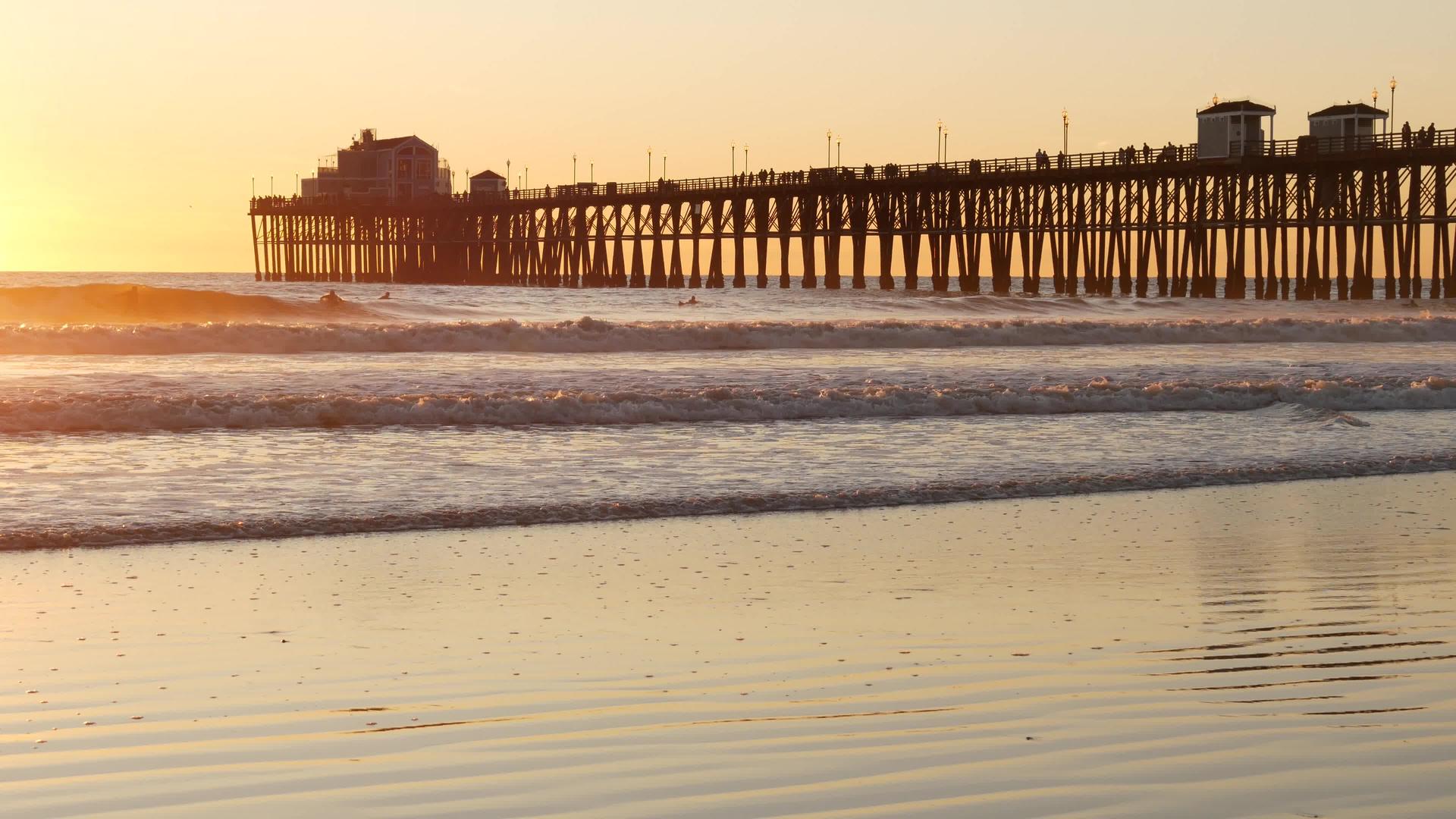 桩上的木码头日落时的剪影加利福尼亚州海滨日落时阳光明媚的海浪视频的预览图