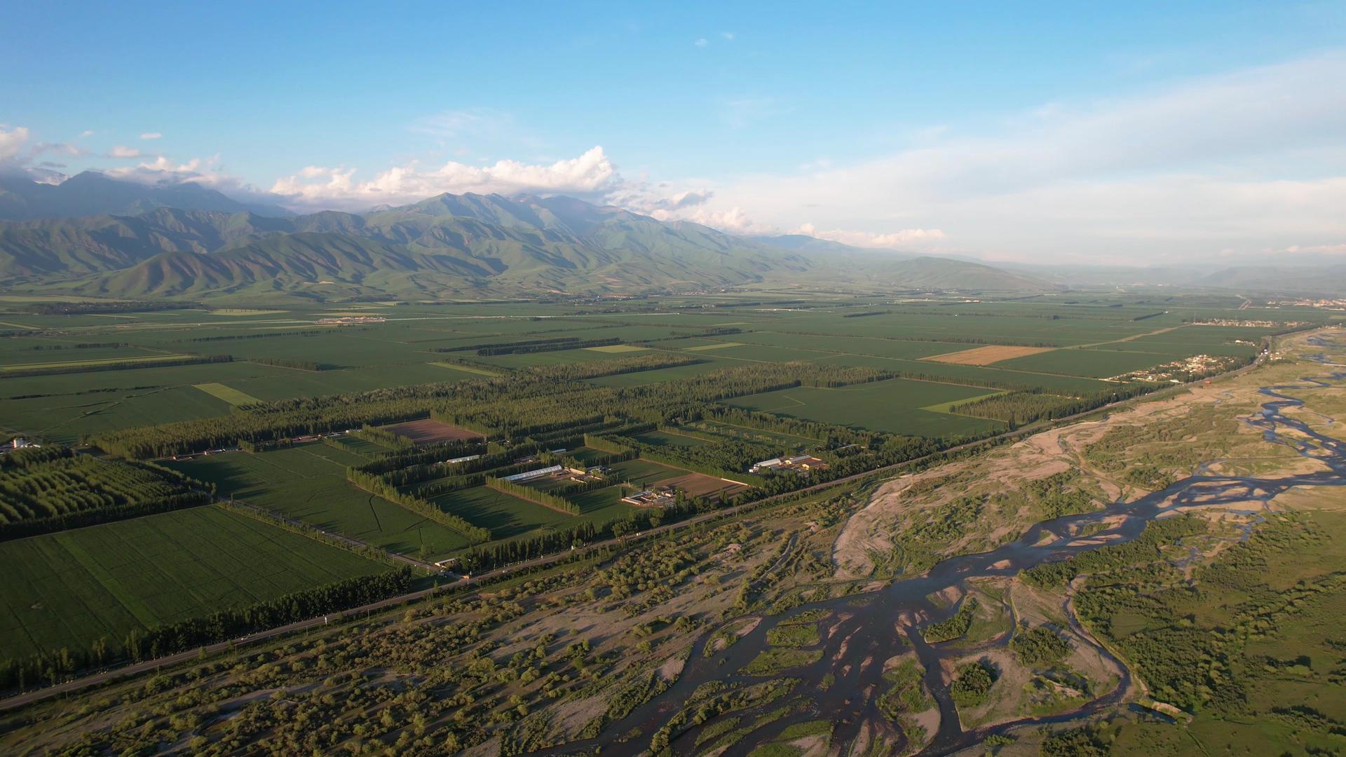 航拍新疆天山山脉下一望无际的河谷草原视频视频的预览图