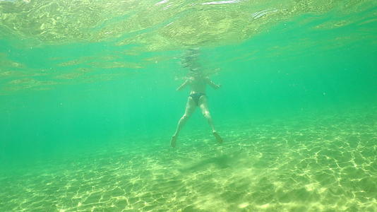 女人在松绿海水中游泳视频的预览图