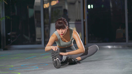 4k健身房健身女性坐姿压腿视频的预览图