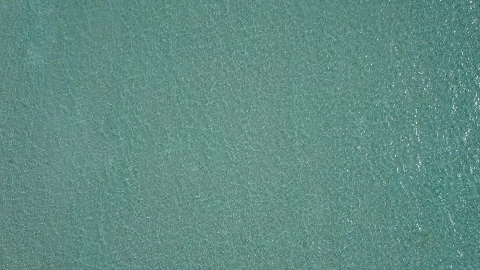 蓝色绿色环礁湖和海滩附近的白色沙滩度假村视频的预览图