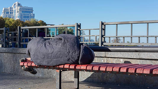 穷人躺在城市公园的长椅上视频的预览图