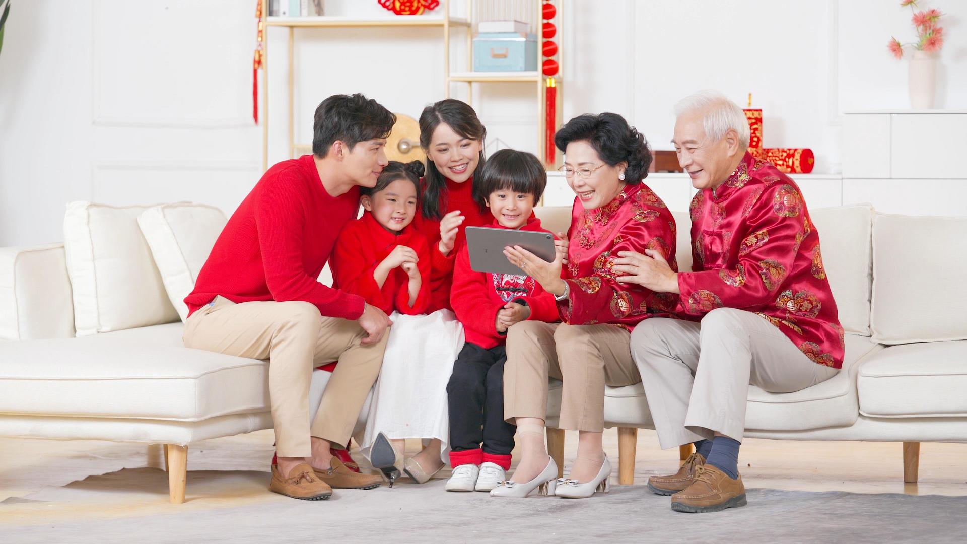 红火过年春节一家人在沙发上和远方亲戚视频通话视频的预览图