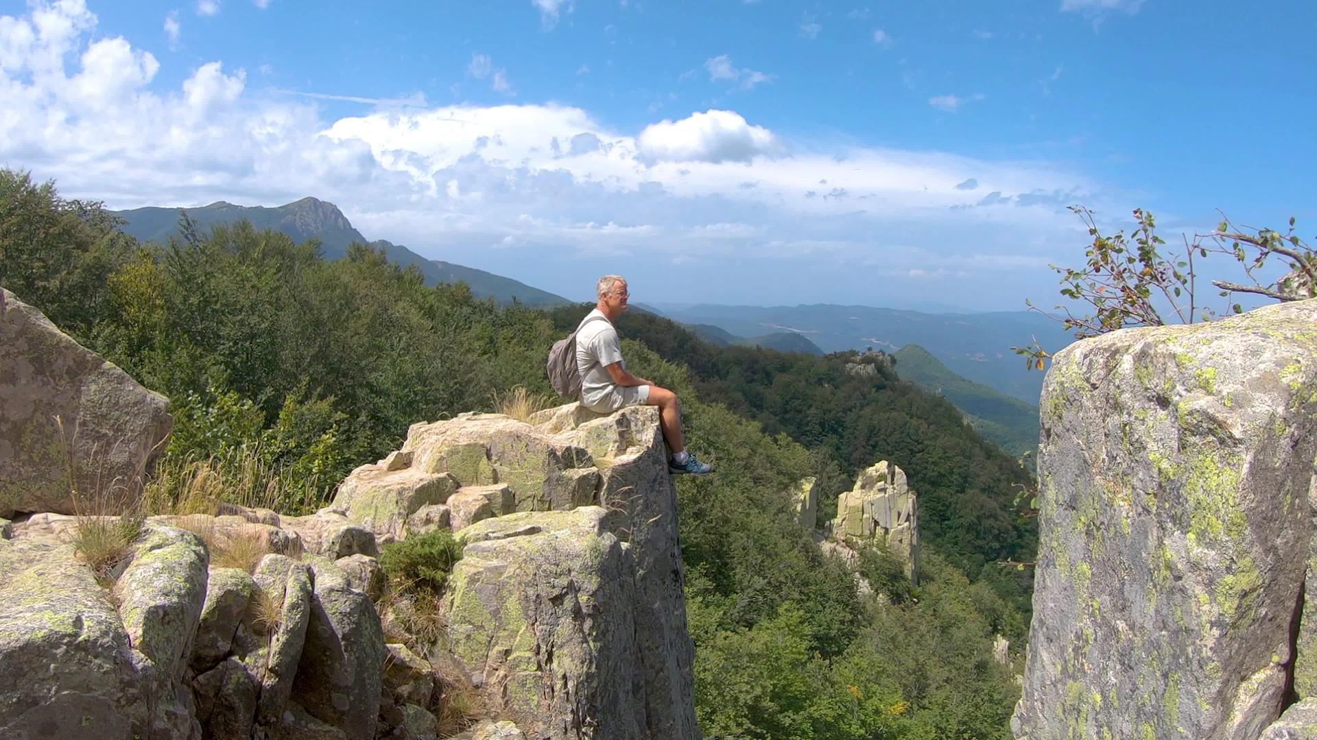 坐在山顶的岩石上位于西班牙河边的西班牙山峰和壮观的山峰视频的预览图