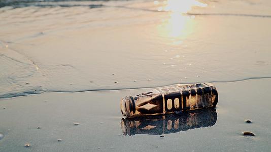 日落时在海滩上洗塑料瓶视频的预览图