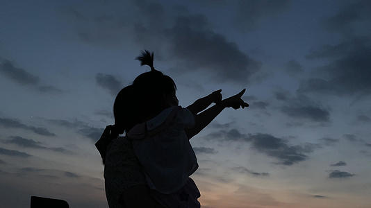 4K实拍夕阳下母女手指向天空的温馨可爱剪影画面视频的预览图