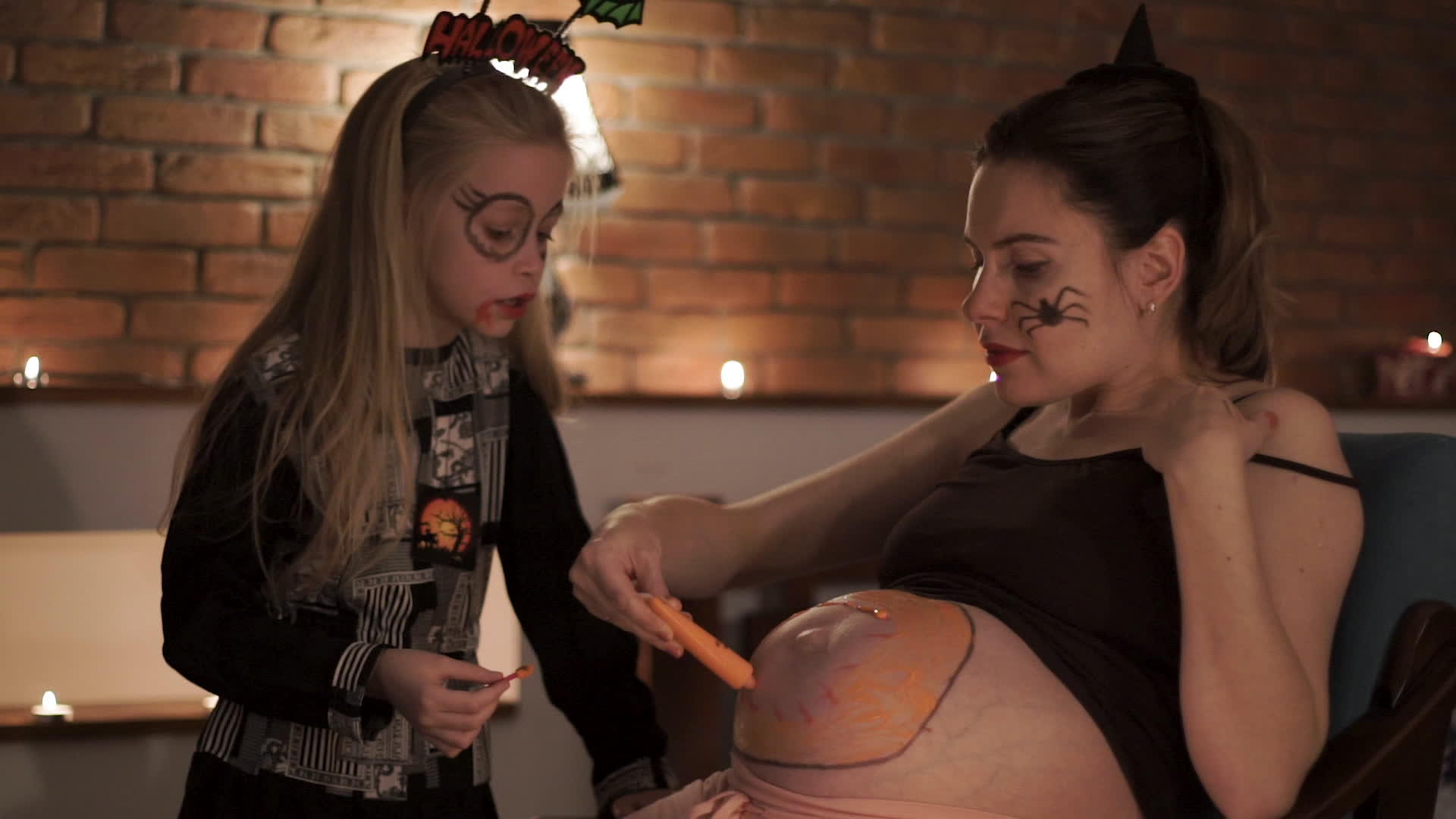怀孕的母亲和女儿在肚子里涂上油漆视频的预览图