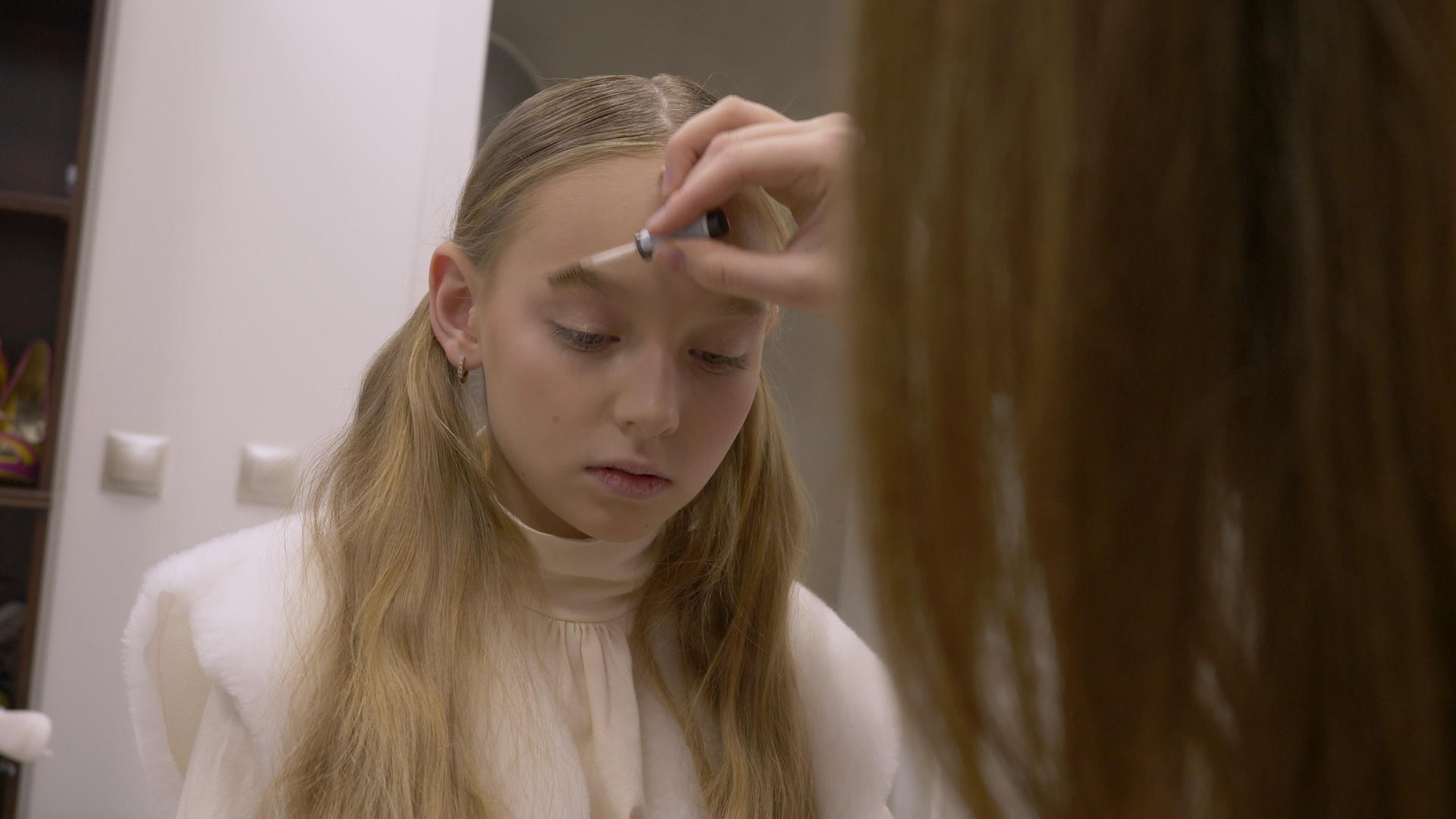 化妆师在美容工作室扮成一个年轻女孩的脸视频的预览图
