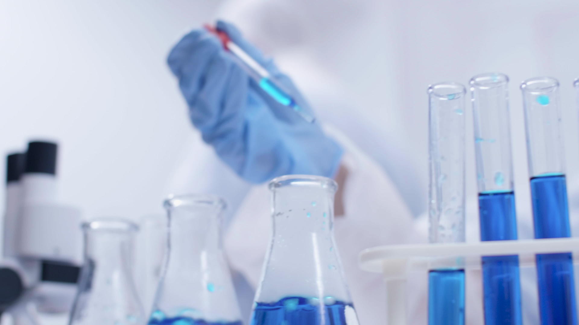 女性科学家用试管中的蓝色液体进行科学测试视频的预览图