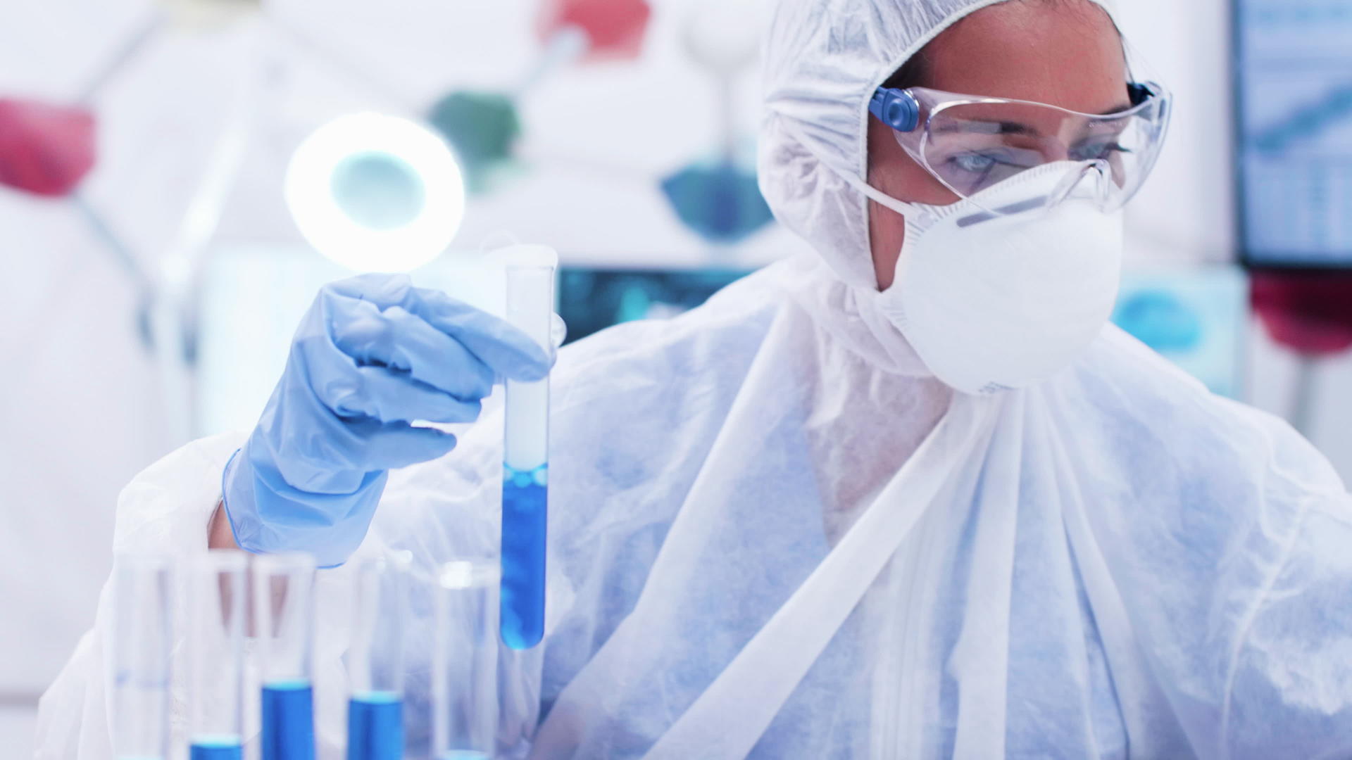 女研究员穿着工作服试管里有一种蓝色的溶液视频的预览图