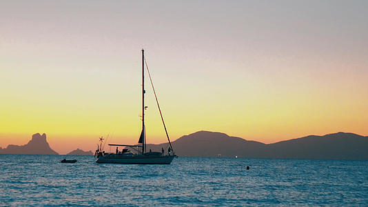 山东日照的海边日落时分帆船飘过视频的预览图