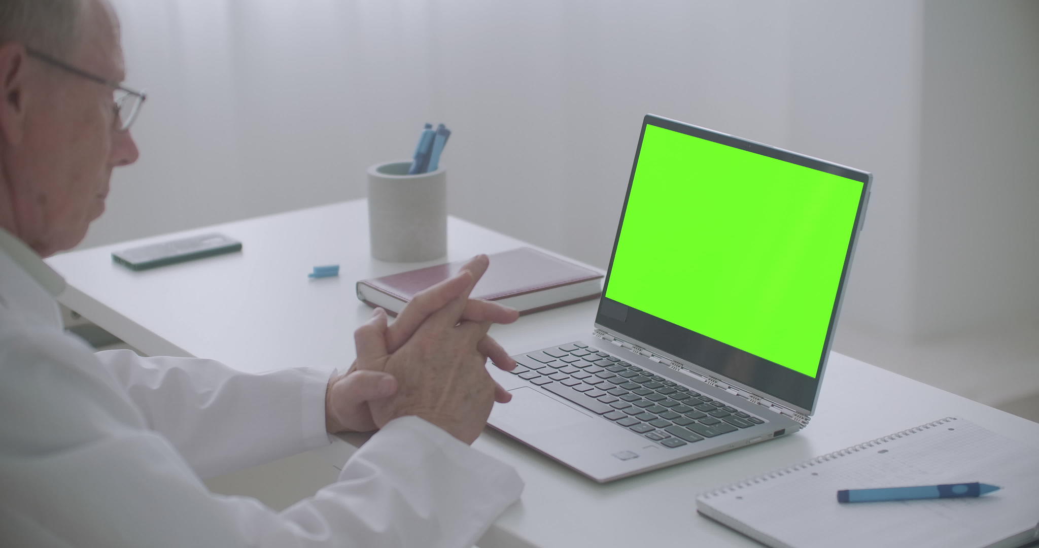 男医生在诊所办公室在线咨询看笔记本电脑绿屏视频的预览图