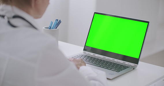 女医生正在寻找一台绿色的膝上电脑用于染色体关键技术视频的预览图