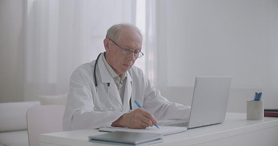 男性医生正在阅读关于教育和高级笔记本屏幕的科学文章视频的预览图