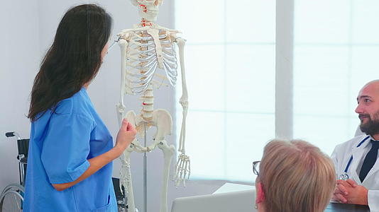 女护士在外科医生面前展示了骨架视频的预览图